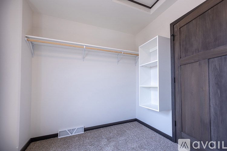 A room with a white wall and a wooden door.