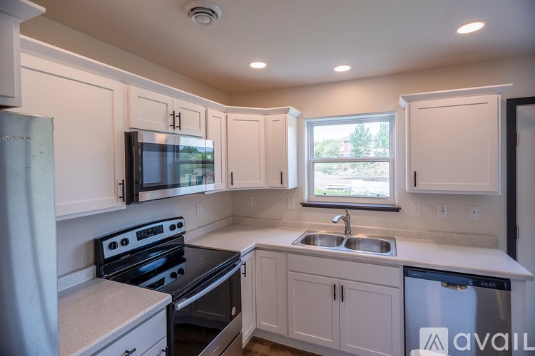A kitchen with white cabinets and a black stove top oven.