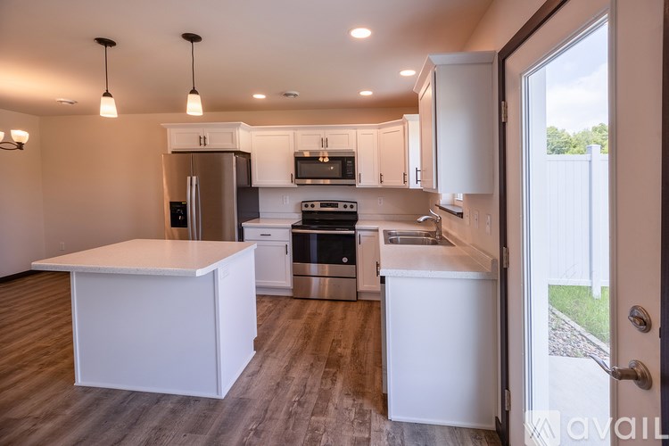 A modern kitchen with white cabinets and stainless steel appliances.