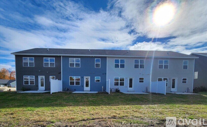A row of houses with the first one on the left being grey and the rest being blue.