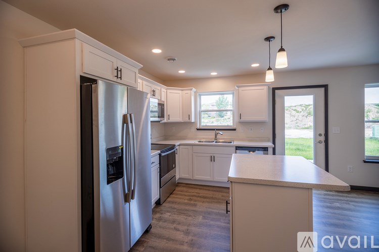 A modern kitchen with a refrigerator, sink, and cabinets.