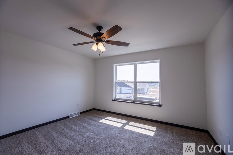 A room with a ceiling fan and a window.