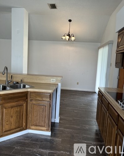 A kitchen with wooden cabinets and a stone floor.