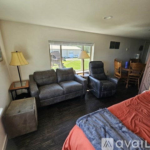 A living room with a grey couch and a black chair.