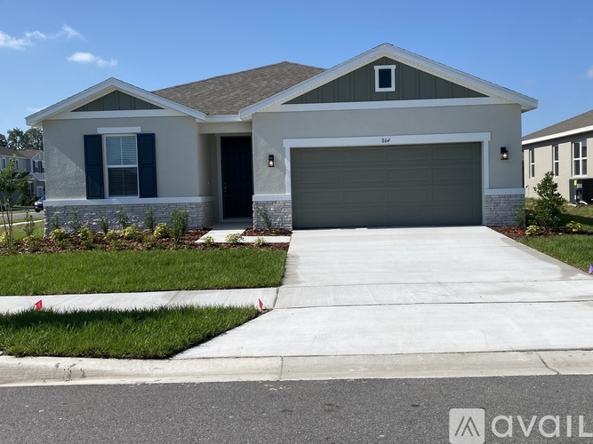 A modern house with a garage door and a driveway.