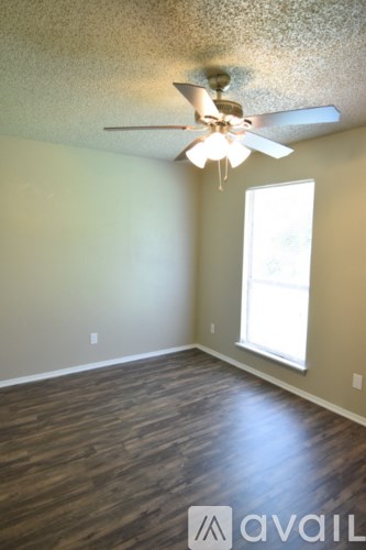 A room with a ceiling fan and wooden flooring.