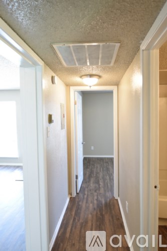 A hallway with wood floors and white walls.