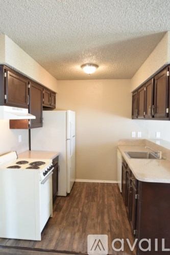 A small kitchen with white appliances and wooden cabinets.