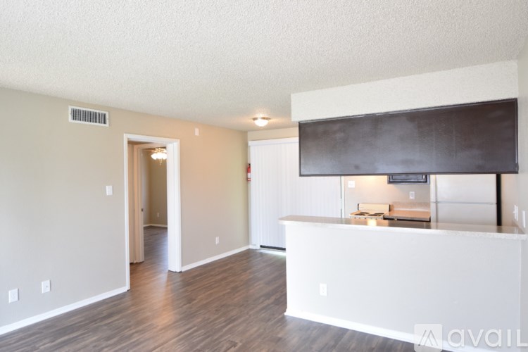 A spacious room with a white reception desk and a television mounted on the wall.