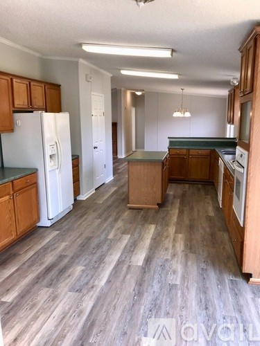 A kitchen with wooden cabinets and a white refrigerator.