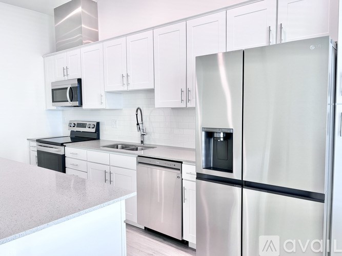 A kitchen with white cabinets and stainless steel appliances.