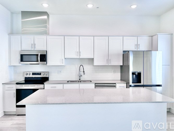 A modern kitchen with white cabinets and appliances.