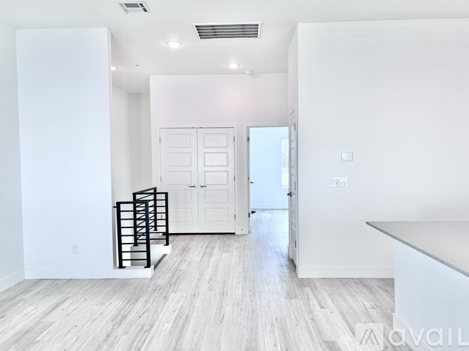 A white room with a wooden floor and a white door.