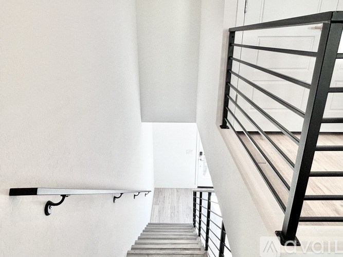 A staircase with a black railing and wooden steps.
