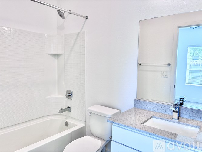 A white toilet sits next to a white bathtub in a bathroom.