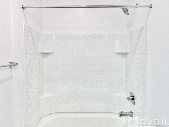 A white bathtub with a glass shower door.