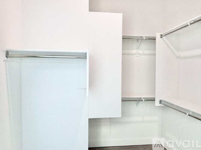 A white door is open in a white room.