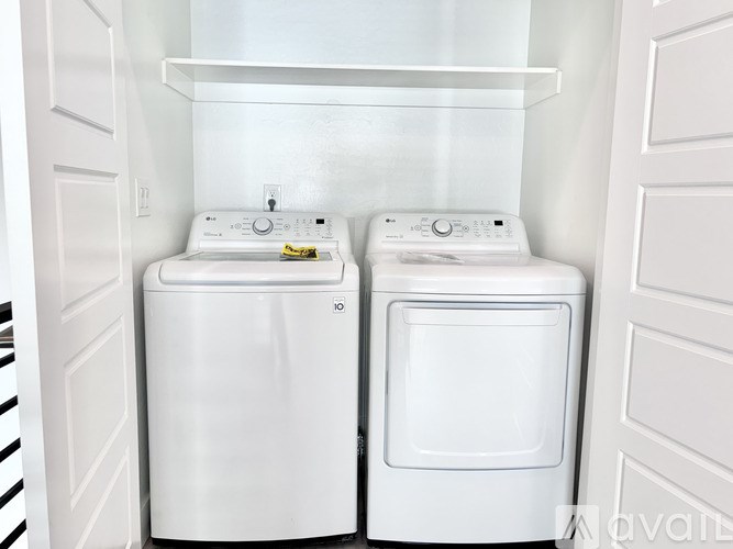 Two white front loading washing machines in a small laundry room.
