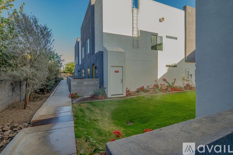 A modern house with a white exterior and a grey roof.