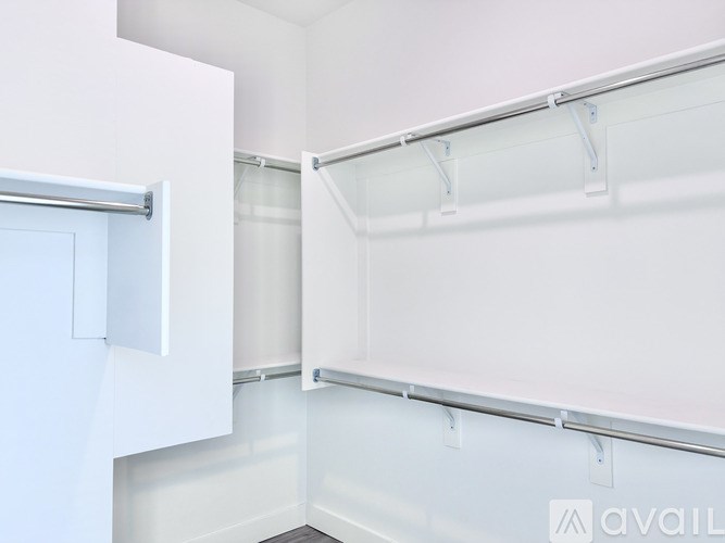A white refrigerator with a door open and a white wall behind it.