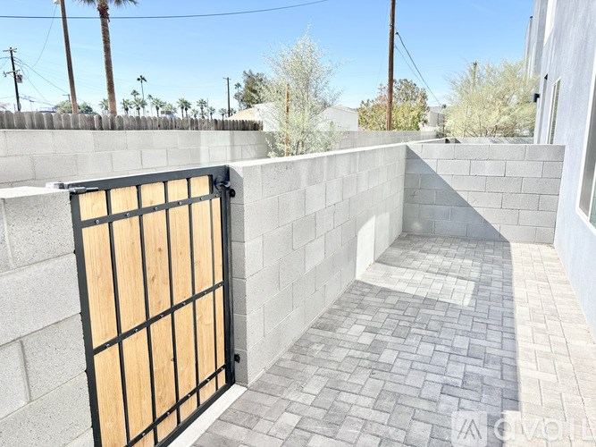 A black gate with a wooden board covering the top is closed.