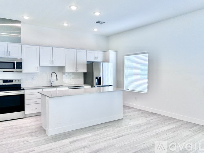 A modern kitchen with white cabinets and a central island.