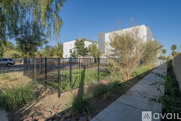 A modern house with a white exterior and a black fence in front.