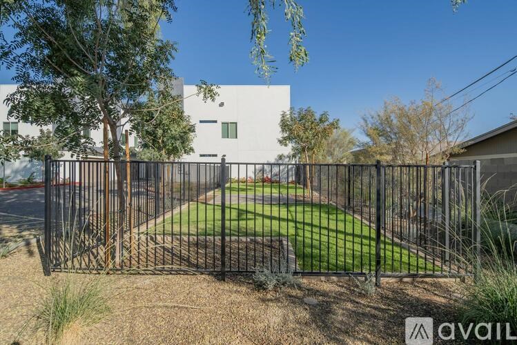 A house with a black fence and a tree in front of it.
