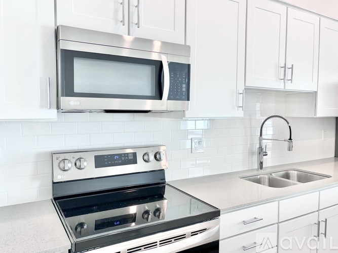 A modern kitchen with a stainless steel oven and microwave.