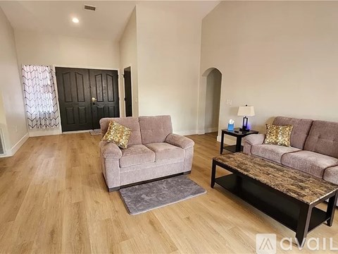 A living room with a grey couch and a wooden coffee table.