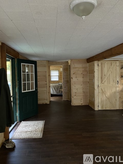 A room with wooden walls and a rug on the floor.