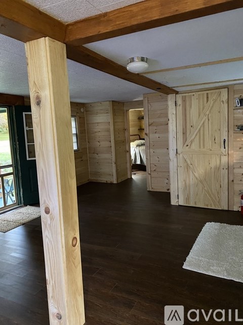 A room with wooden floors and a white ceiling with a light fixture.