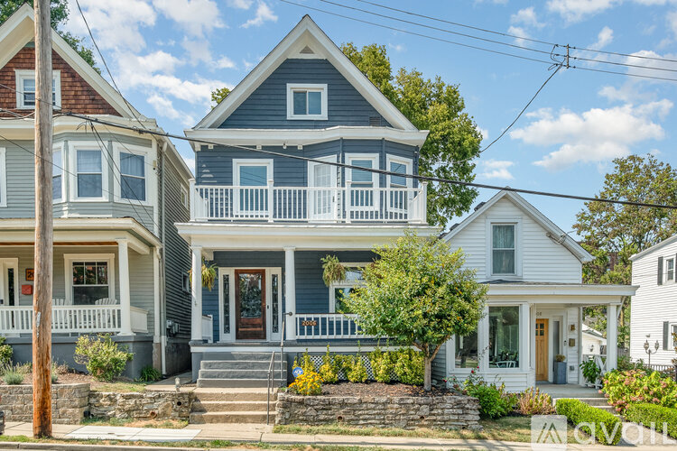 A house with a blue front door and white railings.