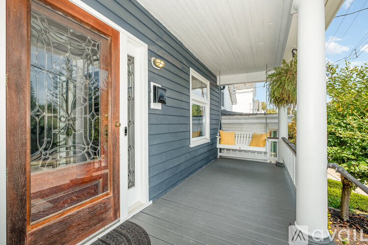 A porch with a white railing and a wooden door.