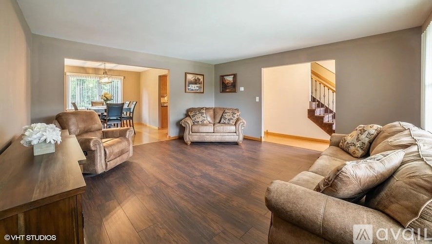 A living room with a brown couch and a wooden floor.