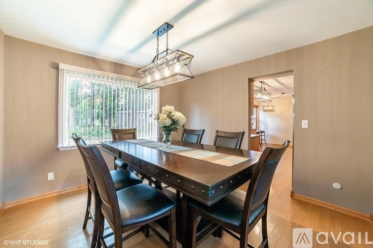 A dining room with a wooden table and chairs.