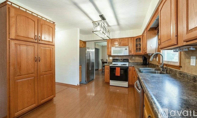 A kitchen with wooden cabinets and a black countertop.