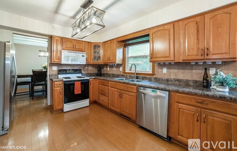 A kitchen with wooden cabinets and a stainless steel dishwasher.