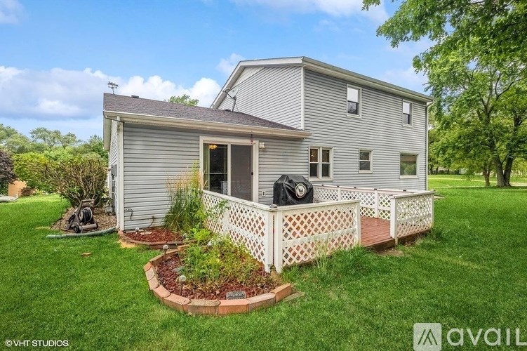 A house with a grey siding and a white picket fence.