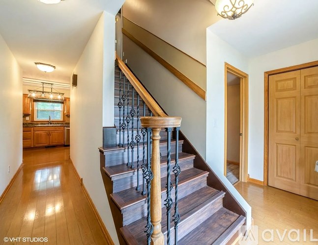 A staircase with a metal railing and wooden steps.