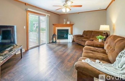 A living room with brown leather couches and a television.