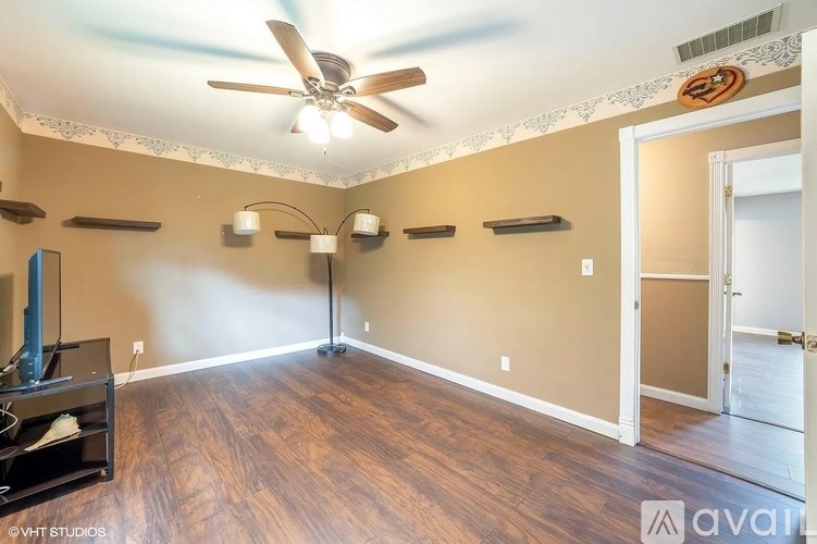A room with a ceiling fan and a fireplace.
