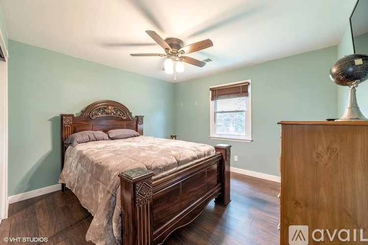 A bedroom with a large bed and a wooden dresser.