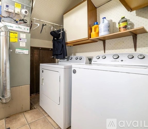 A small laundry room with a washer and dryer.