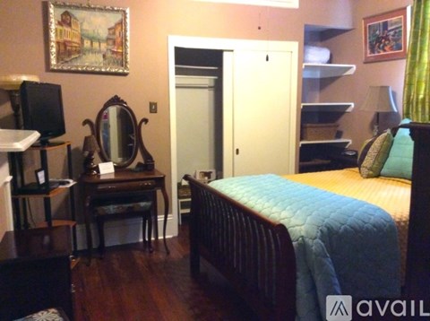 A bedroom with a bed, desk, and chair.