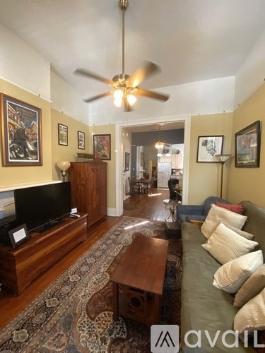 A living room with a television and a rug on the floor.