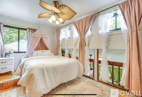 A bedroom with a large bed and a ceiling fan.