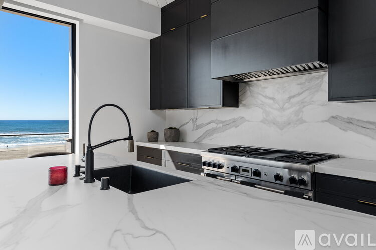 A modern kitchen with a stove top oven and a sink.