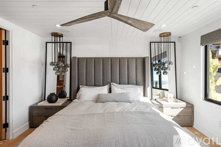 A bedroom with a large bed and a ceiling fan.