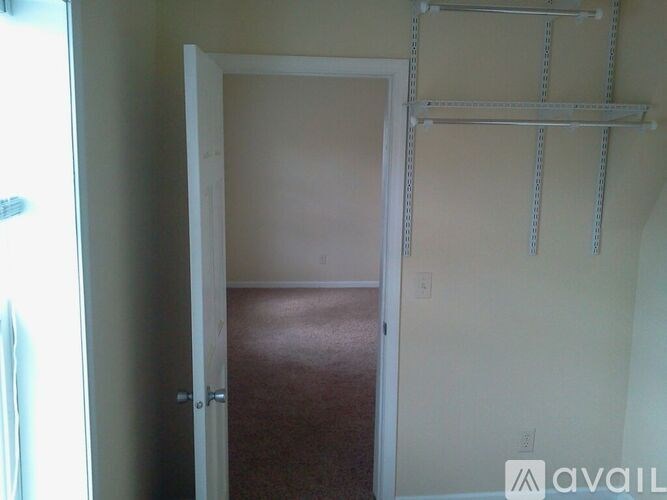 A room with a carpeted floor and a door leading to another room.